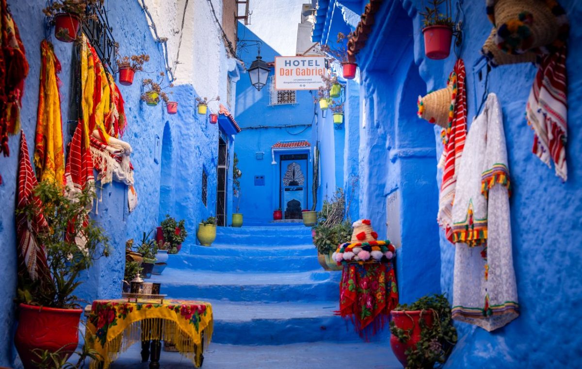 Blue alley in the Chefchaouen medina with woven textiles, on a day trip from Fes
